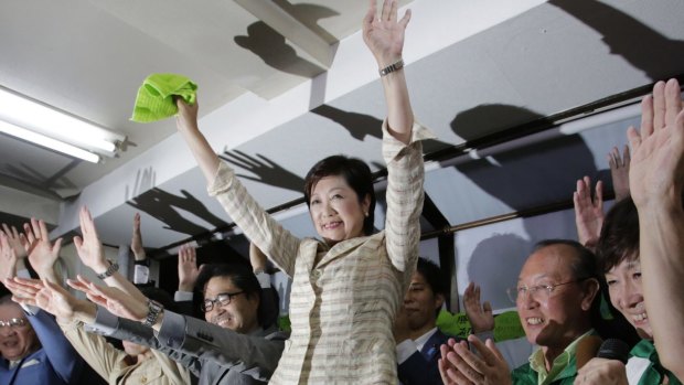 Former defence minister Yuriko Koike, center, and her supporters celebrate her gubernatorial election victory at her election office in Tokyo.