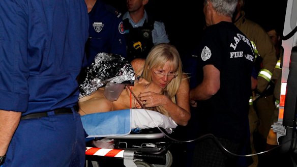 Paramedics treat Brett Connellan at Bombo Beach after the attack. 