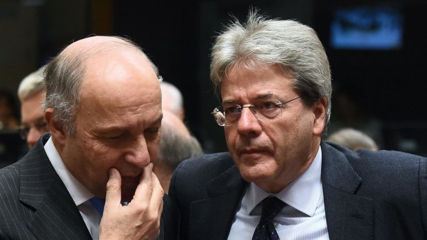 French Foreign Affairs Minister Laurent Fabius (left) speaks with his Italian counterpart, Paolo Gentiloni,  during an EU foreign affairs council at the European Council in Brussels.