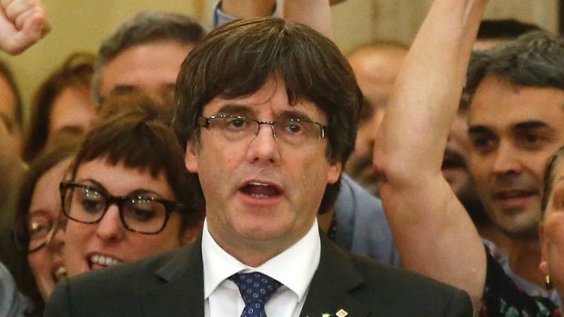 Catalan President Carles Puigdemont sings the Catalan anthem inside the parliament after a vote on independence.