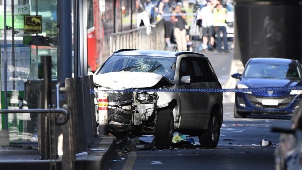 A damaged vehicle is seen at the scene of an incident on Flinders Street.
