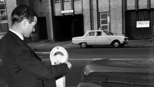 A man uses a parking meter on Russell Street in 1961.