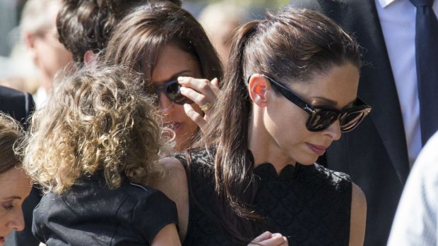 Erica Baxter with her daughter at the funeral of her father, Michael.