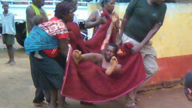 An injured man is carried in a blanket in the town of Caphiridzange, Mozambique after the tanker exploded.