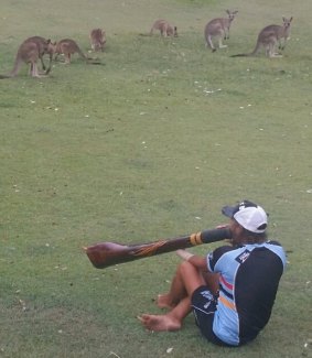 Jason Morris playing the didgeridoo to a captive audience