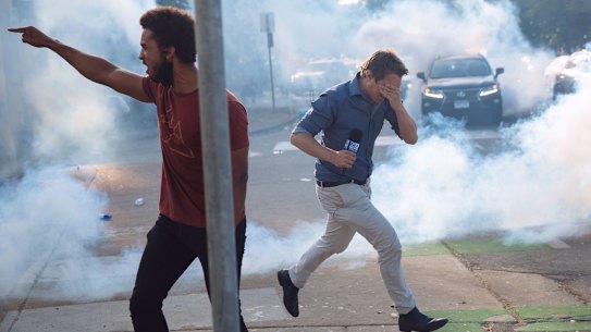 Nine reporter Tim Arvier runs from police tear gas amid the Los Angeles protests over the police killing of George Floyd.