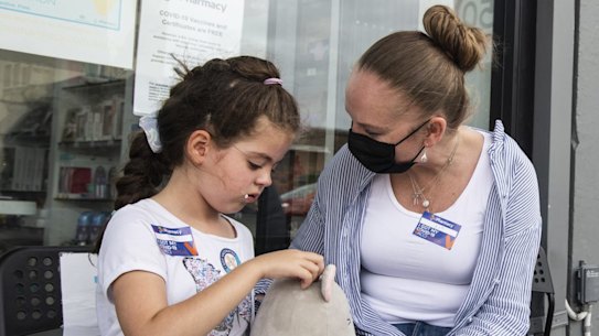 A mother comforts her daughter after receiving the coronavirus jab in Sydney. 