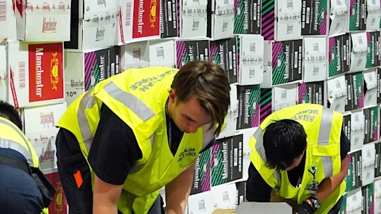 The Australian Border Force officers check illegal cigarette imports found in shipping containers in Melbourne.