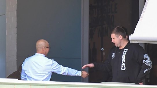 Former CFMEU NSW assistant secretary Michael Greenfield (right) and secretary Darren Greenfield (left, obscured) at union headquarters with an employer they received $5000 bribes from.