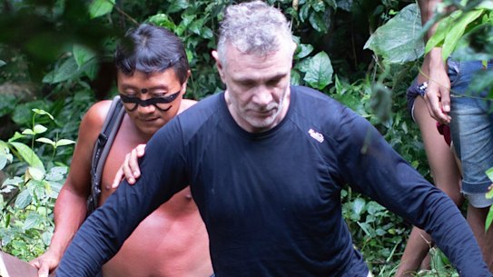 British journalist Dom Phillips, right, and a Yanomami Indigenous man walk in Maloca Papiu village, Roraima state, Brazil, in 2019.