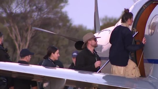German backpacker Carolina Wilga, who was missing in WA’s outback for almost two weeks, is led to a plane after being found alive and well on Friday.