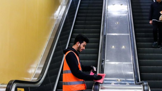 A cleaner disinfects public transport. The Train station that connects to the bus staion at Bondi Junction.. Coronavirus, 24th May 2020. Photo: Edwina Pickles / SMH