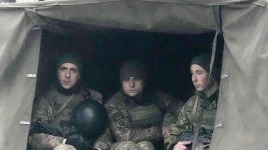 Ukrainian soldiers ride in a military vehicle in Mariupol, Ukraine.