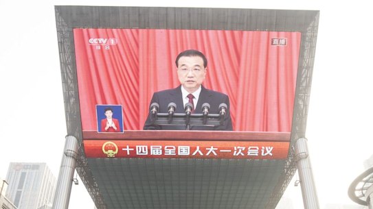 A screen displays a news broadcast of Li Keqiang, China’s premier, during the opening of the First Session of the 14th National People’s Congress (NPC) at the Great Hall of the People in Beijing.