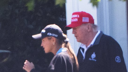 President Donald Trump heads to the golf course on Sunday with his granddaughter Kai Trump.
