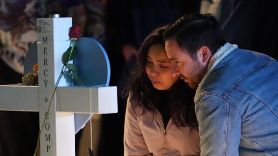 People embrace during a candlelight vigil on a corner near the site of a weekend mass shooting at a gay bar, late Monday, Nov. 21, 2022, in Colorado Springs, Colo. (AP Photo/Jack Dempsey)