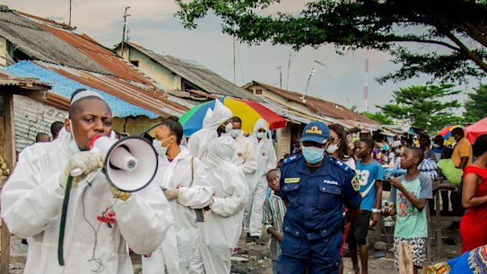 Members of the Filimbi advocacy group lead a coronavirus awareness march through a market in the DRC.