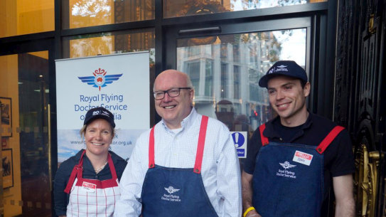 Australia’s High Commissioner to the UK George Brandis serves democracy sausages to voters at Australia House in London. 
