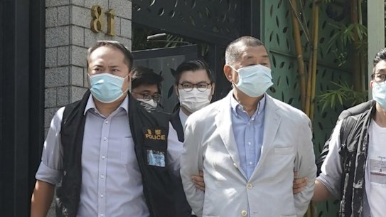 Hong Kong media tycoon Jimmy Lai, center, who founded local newspaper Apple Daily, is arrested by police officers at his home in Hong Kong, Monday, Aug. 10, 2020. Lai was arrested Monday on suspicion of collusion with foreign powers, his aide said, in the highest-profile use yet of the new national security law Beijing imposed on the city after protests last year. (AP Photo)