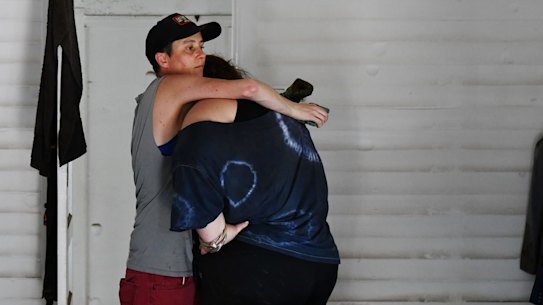 Water levels are dropping and clean up has begun after severe flooding hits Lismore in northern NSW in the worst flood ever recorded on Wednesday March 2 2022. Kym Strow lost her business in town and home with her partner  on Dawson Street. Kym is comforted by a friend after seeing video of her business she has in town with her partner Sarah Jones. Photo: Elise Derwin / SMH. .