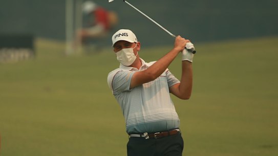 New Zealand golfer Ryan Chisnall wears a mask as thick smog blanketed The Australian Golf Club during the opening round of the Australian Open on Thursday.
