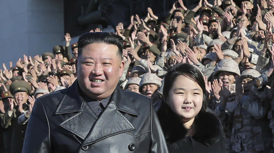 North Korean leader Kim Jong-un (centre) and his daughter pose with soldiers who were involved in the launch of a Hwasong-17 intercontinental ballistic missile.