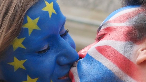 Young people  kiss each other  at Brandenburg Gate in Berlin, Germany, during a demonstration in support of the Remain campaign.