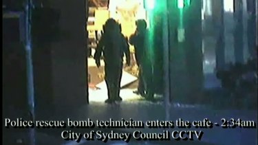 Bomb squad technicians enter the cafe after the siege.