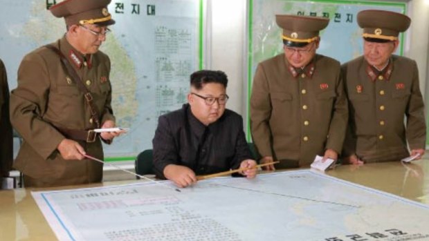 Kim Jong-un consults maps of proposed missile launches to Guam, in this image published by North Korean state media on Tuesday.