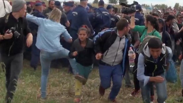 Hungarian camerawoman Petra Laszlo, centre left in blue, kicks out at a young migrant in Hungary on September 8. 