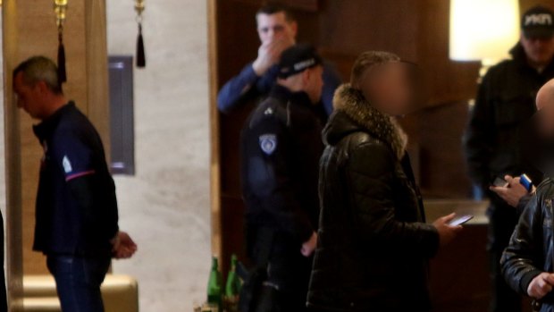 Rohan Arnold, on left, is detained in the lobby of a Belgrade hotel.