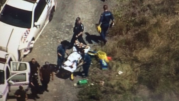 Paramedics treat a man shot in the leg in bushland at Kingston.