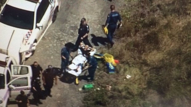 Paramedics treat a man shot in the leg in bushland at Kingston.
