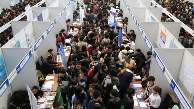 Large crowds pack into a job fair at the Tianjin University Sports Arena, China.