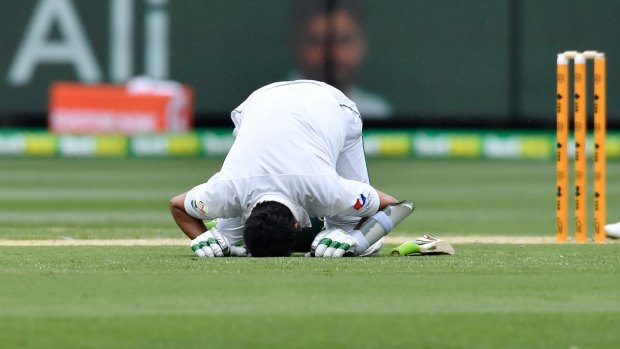 Patient and tough: Pakistan's Azhar Ali kisses the ground after scoring a century against Australia on the second day of the Test in Melbourne.