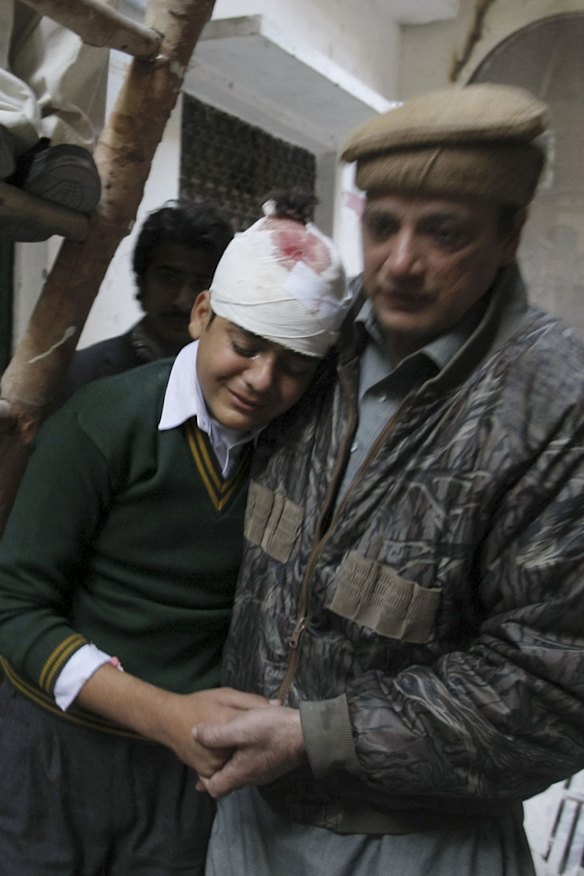 Student Mohammad Baqir is comforted by his uncle after learning that his mother, a teacher at the school, was killed.