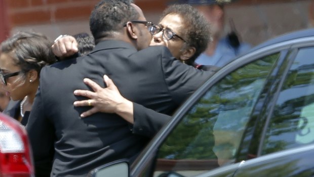 Bobby Brown hugs an unidentified woman after the service.