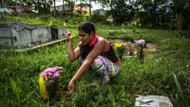 Melida visits the grave of a cousin who, like her, was pressed into service at a young age by guerrilla fighters.