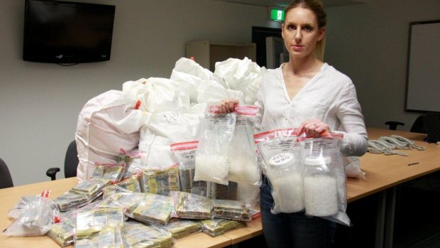 A police officer with the cash and drug haul linked to the money laundering syndicate