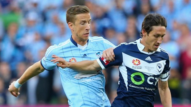 Mark Milligan of the Victory is tackled by Marc Janko of Sydney FC  during the 2015 A-League grand final.