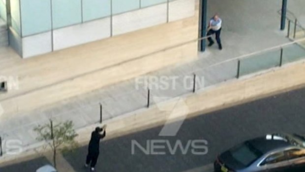 Farhad Khalil Mohammad Jabar aims his gun at a police officer.