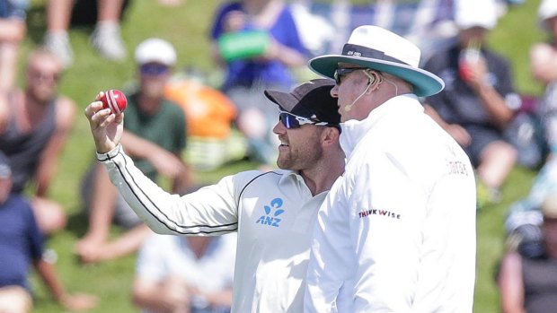 New Zealand captain Brendon McCullum expresses concern at the shape of the ball to umpire Steve Davis.

