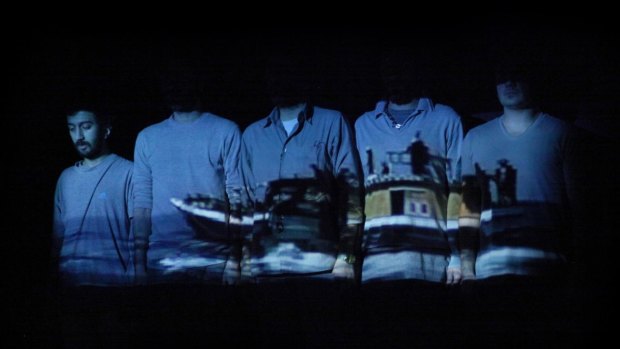 A scene from <i>Manus</i> with a projection of an asylum seeker boat