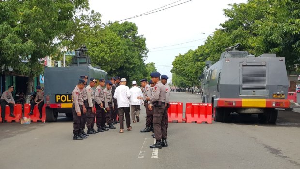 A blocked-off street and two water cannon trucks outside the court where Abu Bakar Bashir's trial is taking place in Cilacap, Indonesia.