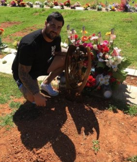 Sad return: Andrew Fifita with the NRL trophy at the gravesite of one of his close friends.