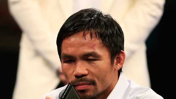 Questions: Manny Pacquiao points to his injured right shoulder.