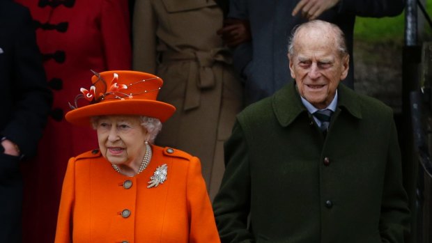 Britain's Queen Elizabeth II and Prince Philip, right, wait for their car following the traditional Christmas Day church service, at St. Mary Magdalene Church in Sandringham, England, Monday, Dec. 25, 2017. (AP Photo/Alastair Grant)
