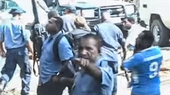 Papua New Guinea police leading Dame Carol Kidu away.