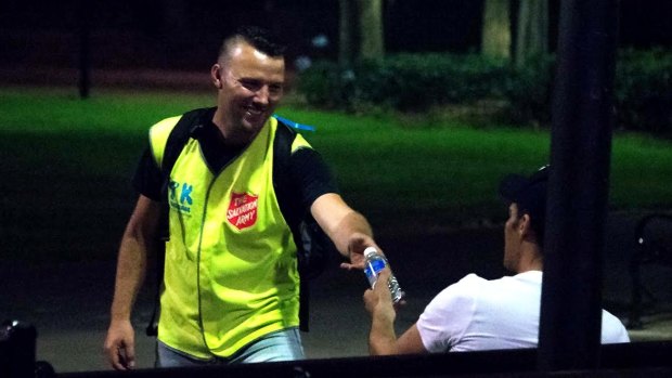 Take Kare co-ordinator Nate Brown offers a bottle of water to a late-night reveller.