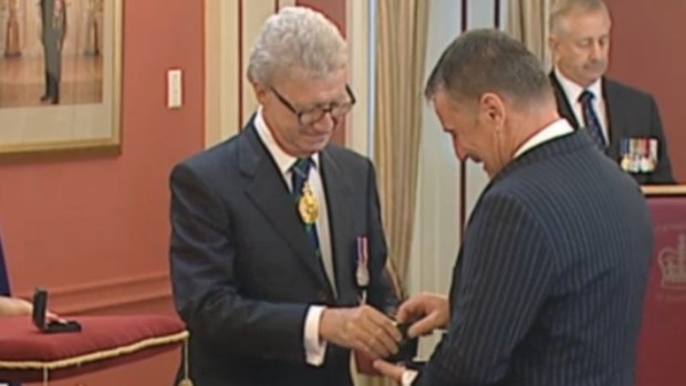 Queensland Governor Paul de Jersey presents a bravery award to John Tyson, who received it on behalf of his late son Jordan Rice. Jordan died a hero in the 2011 floods when he insisted his younger brother, then aged 10, be rescued first.
